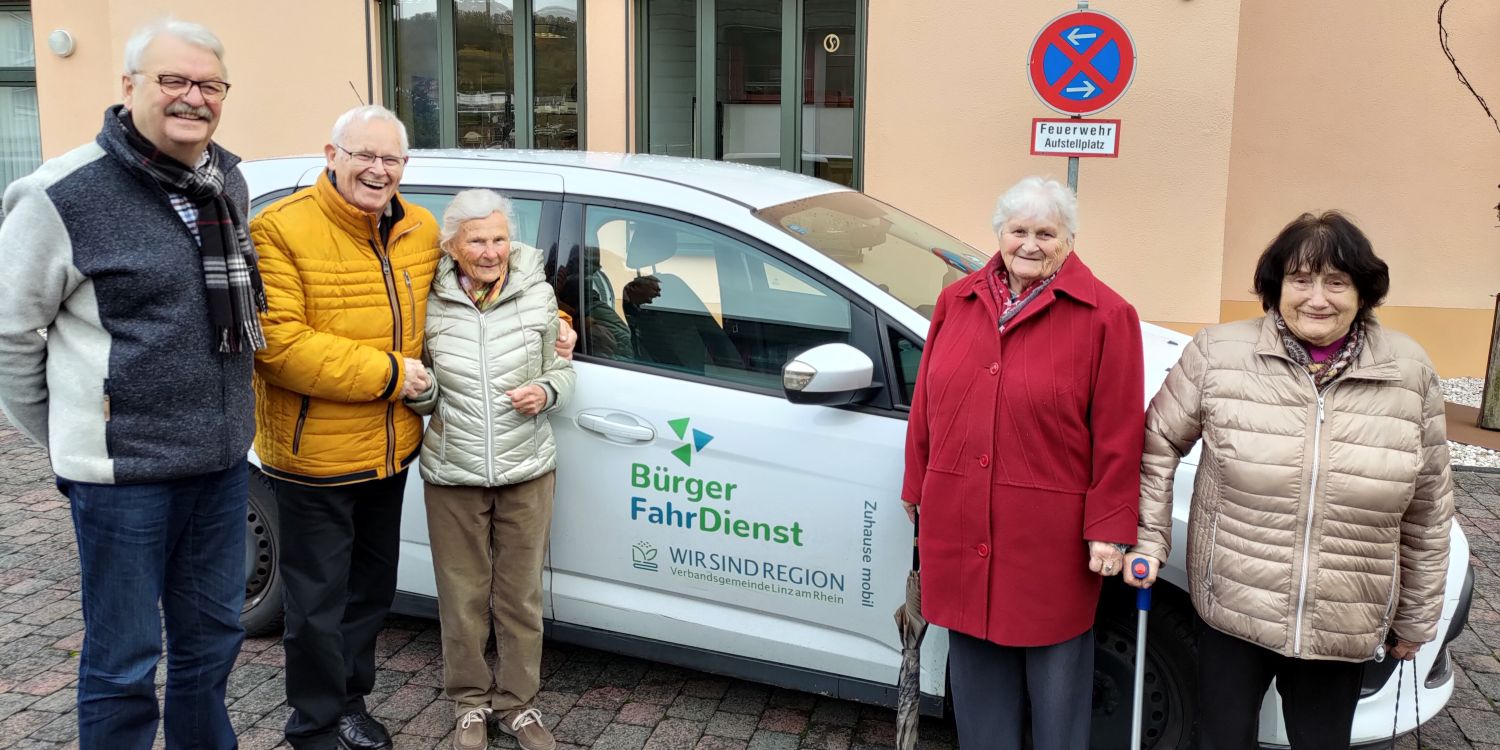 Personen vor einem Auto